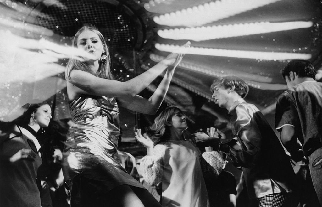 A teenage girl wearing a metallic dress dancing at a discotheque, September 1991 (Photo by Chris McHugh)