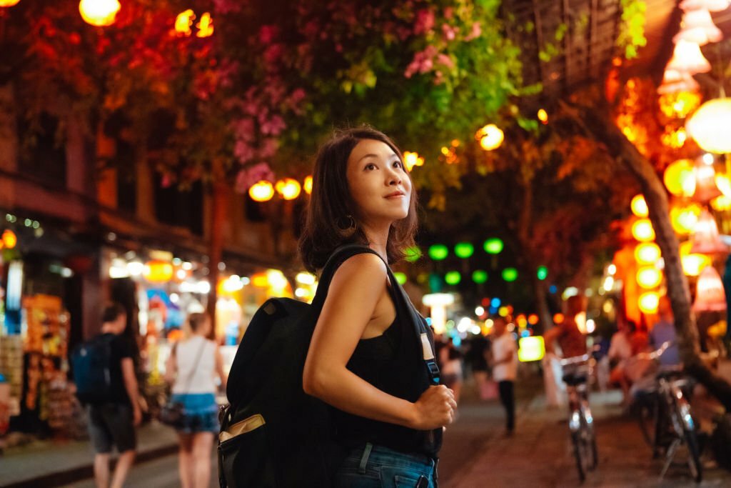 Young female traveler exploring local market at night in New York.