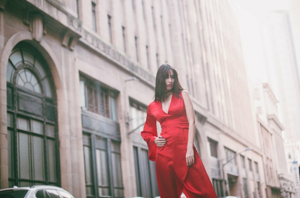 Stunning and beautiful woman in red dress out in the city, on a lovely day.
