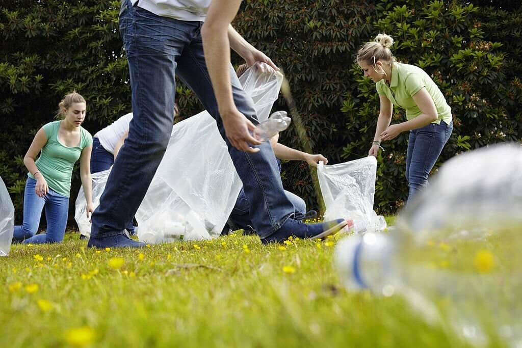 People cleaning up litter on grass